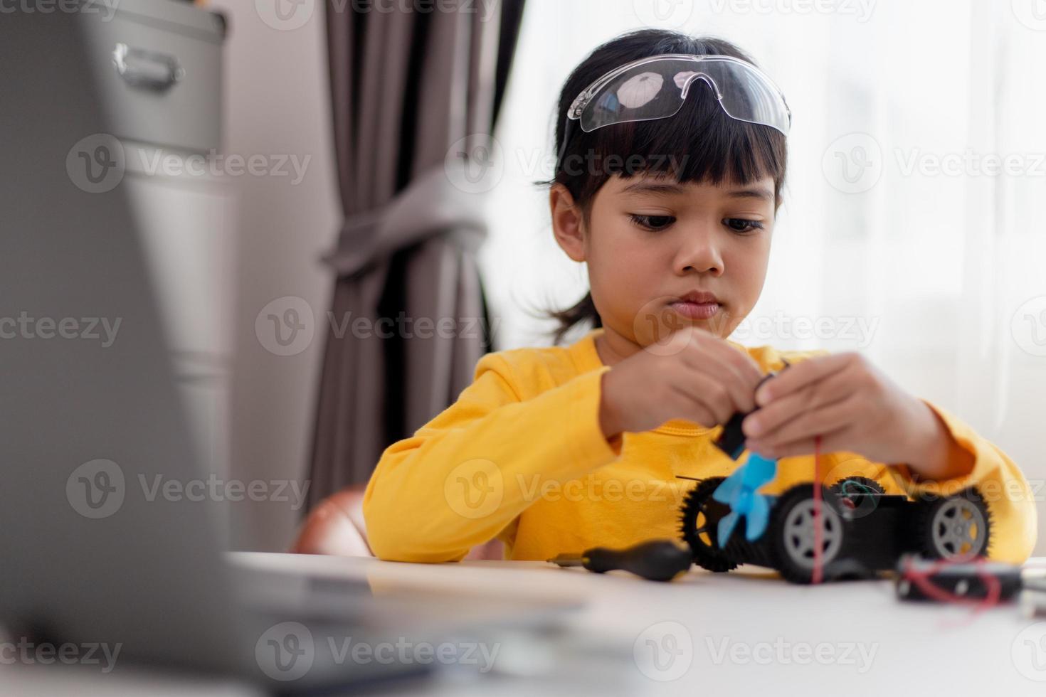 Asia students learn at home in coding robot cars and electronic board cables in STEM, STEAM, mathematics engineering science technology computer code in robotics for kids concept. photo