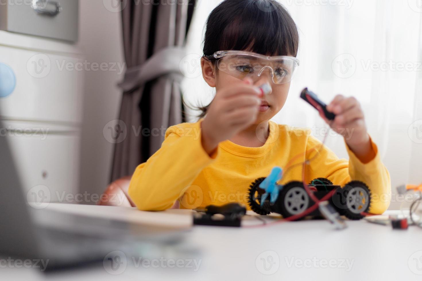 Asia students learn at home in coding robot cars and electronic board cables in STEM, STEAM, mathematics engineering science technology computer code in robotics for kids concept. photo