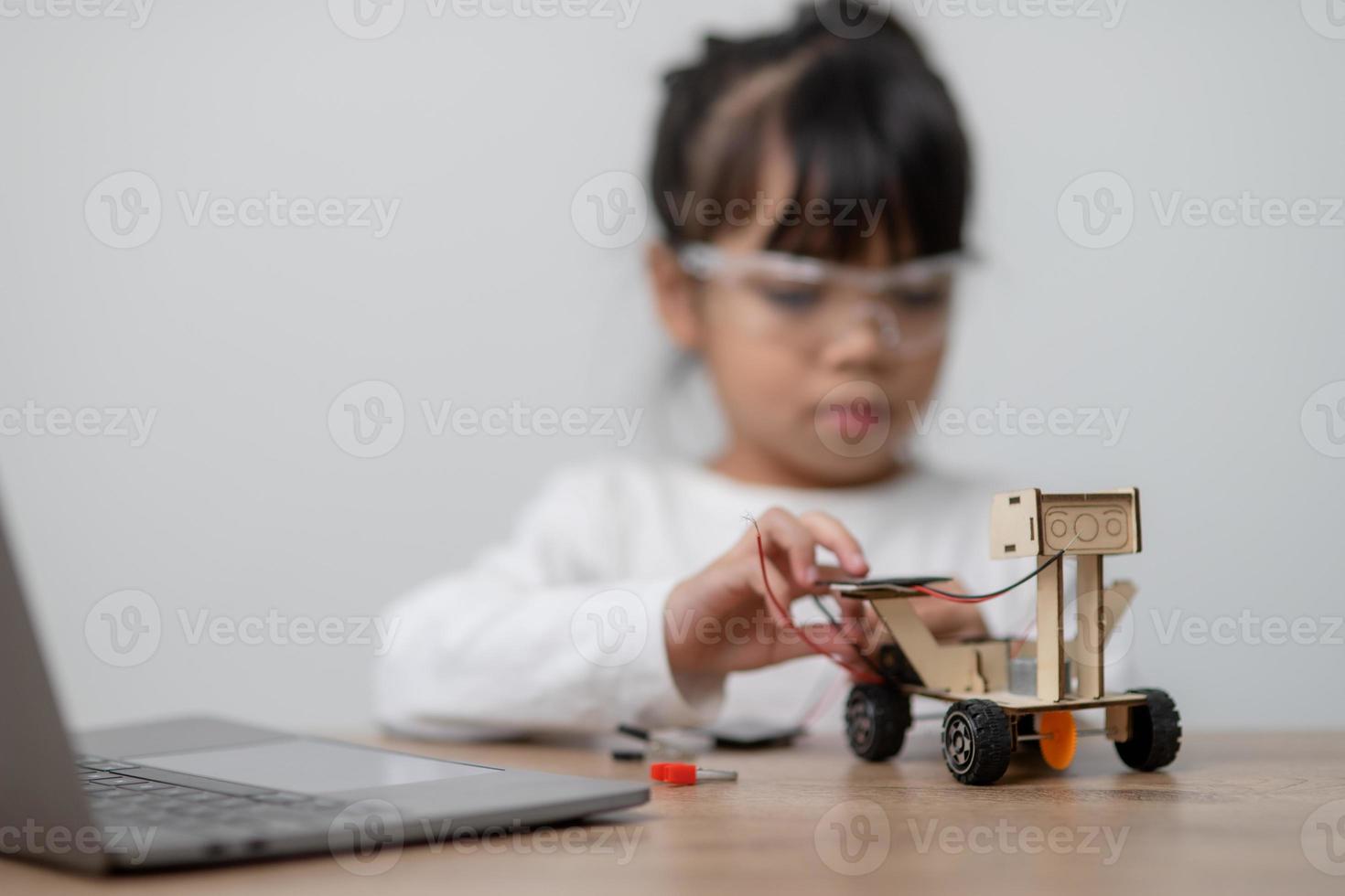 Asia students learn at home in coding robot cars and electronic board cables in STEM, STEAM, mathematics engineering science technology computer code in robotics for kids concept. photo
