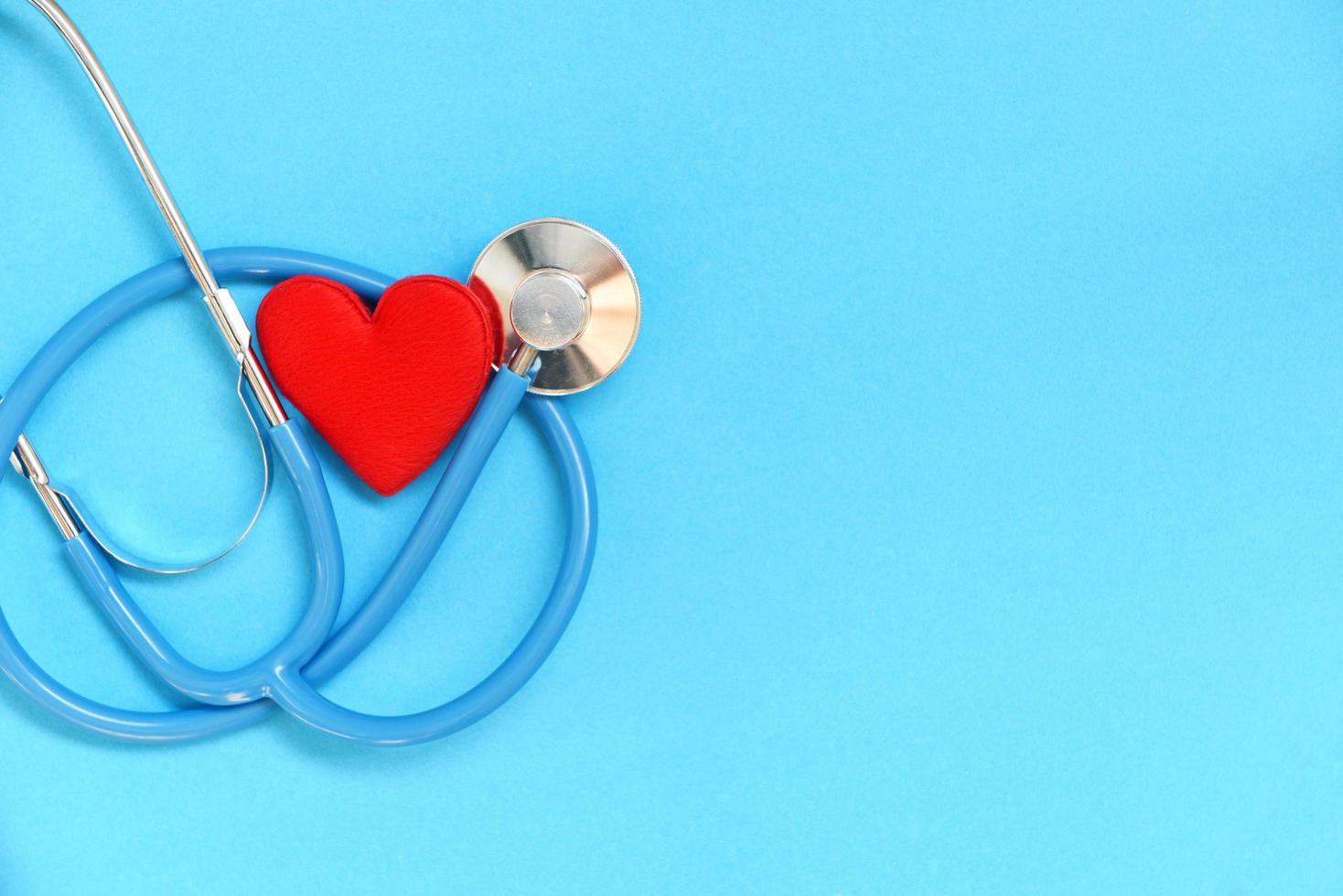 Heart health and red heart with stethoscope on blue background - world heart day world health day or world hypertension day and health insurance concept photo