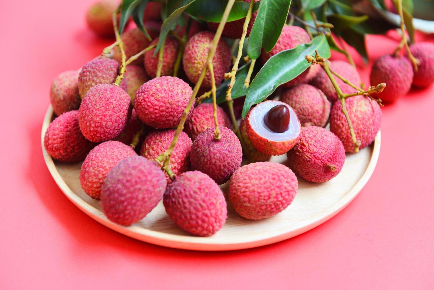 lichi con cosecha de hojas verdes en placa de madera de fruta tropical de árbol foto