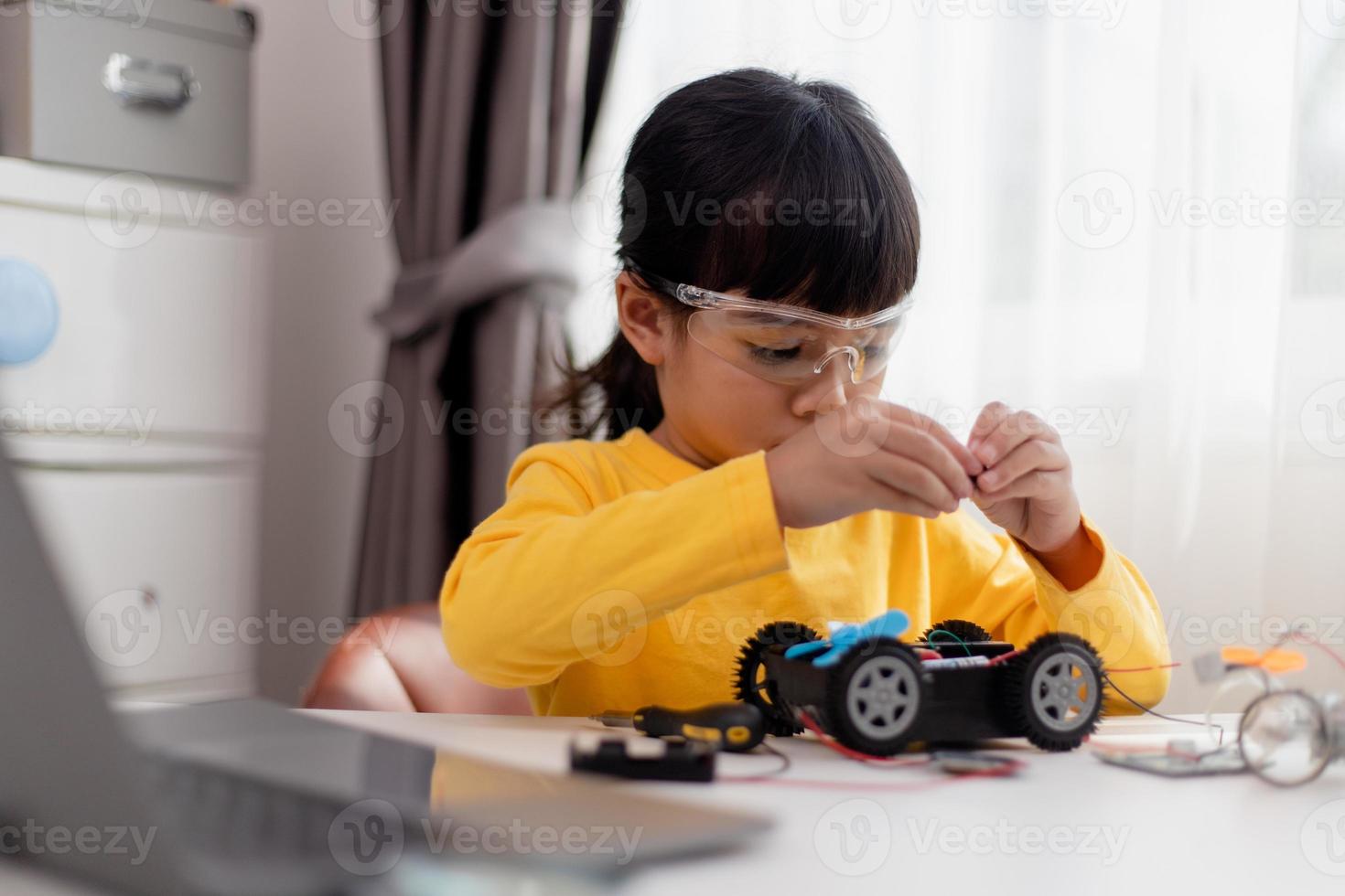 Asia students learn at home in coding robot cars and electronic board cables in STEM, STEAM, mathematics engineering science technology computer code in robotics for kids concept. photo