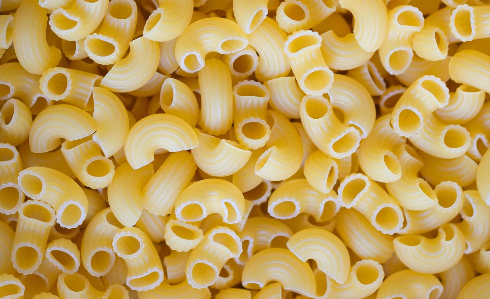 fondo de pasta, fondo de textura de macarrones crudos, pasta de macarrones crudos de cerca pasta deliciosa sin cocer para cocinar alimentos foto