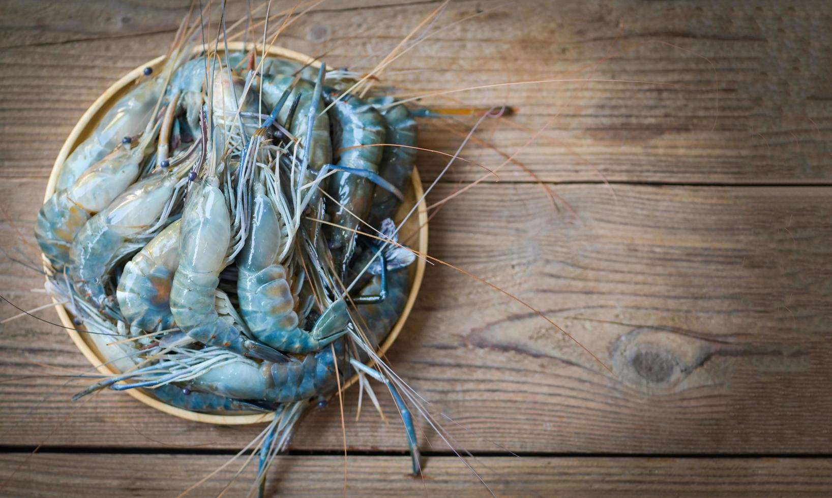 camarones crudos sobre fondo de madera de placa para cocinar alimentos, camarones o gambas frescas, estantes de mariscos foto