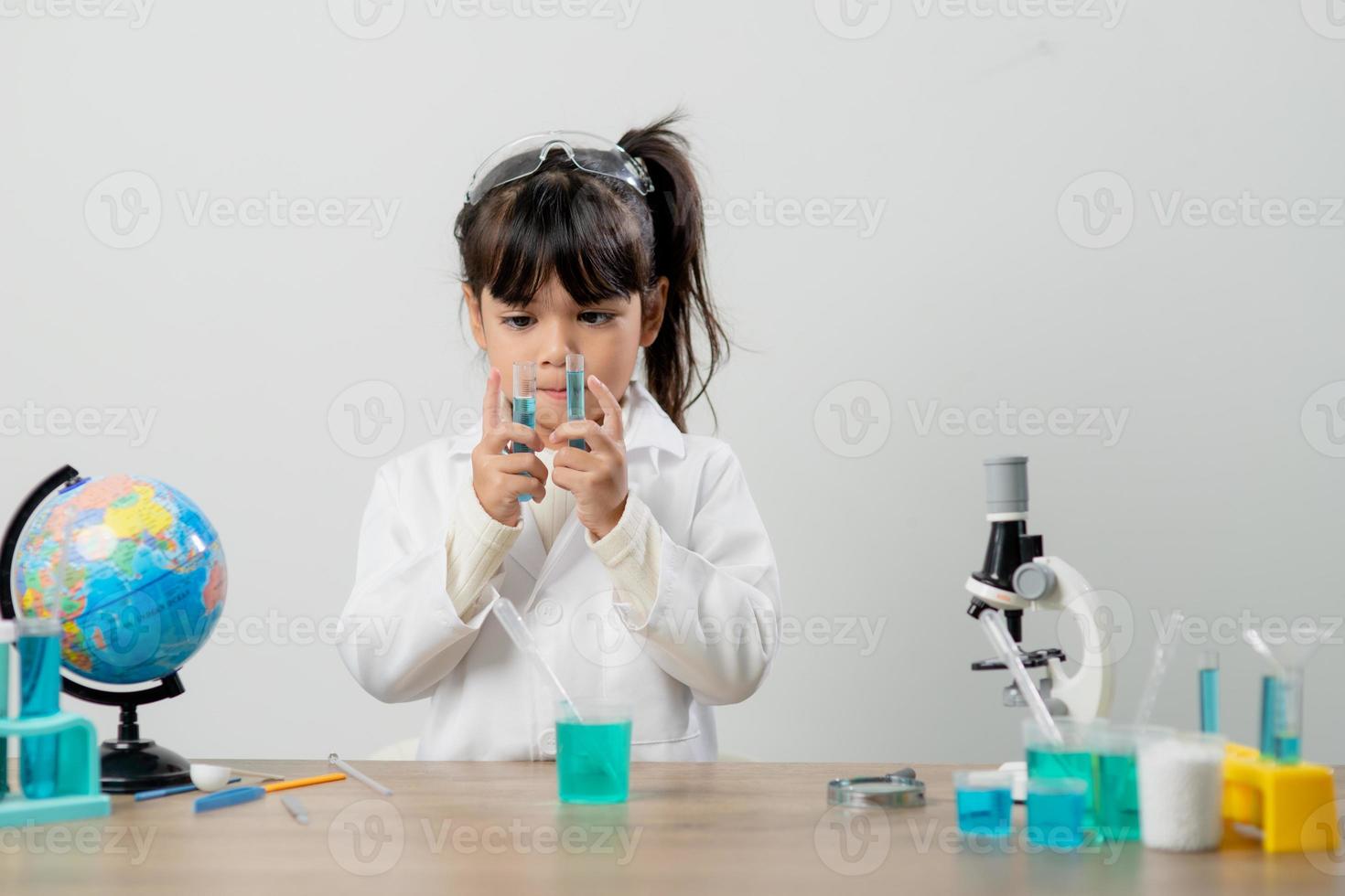 education, science, chemistry and children concept - kids or students with test tube making experiment at school laboratory photo