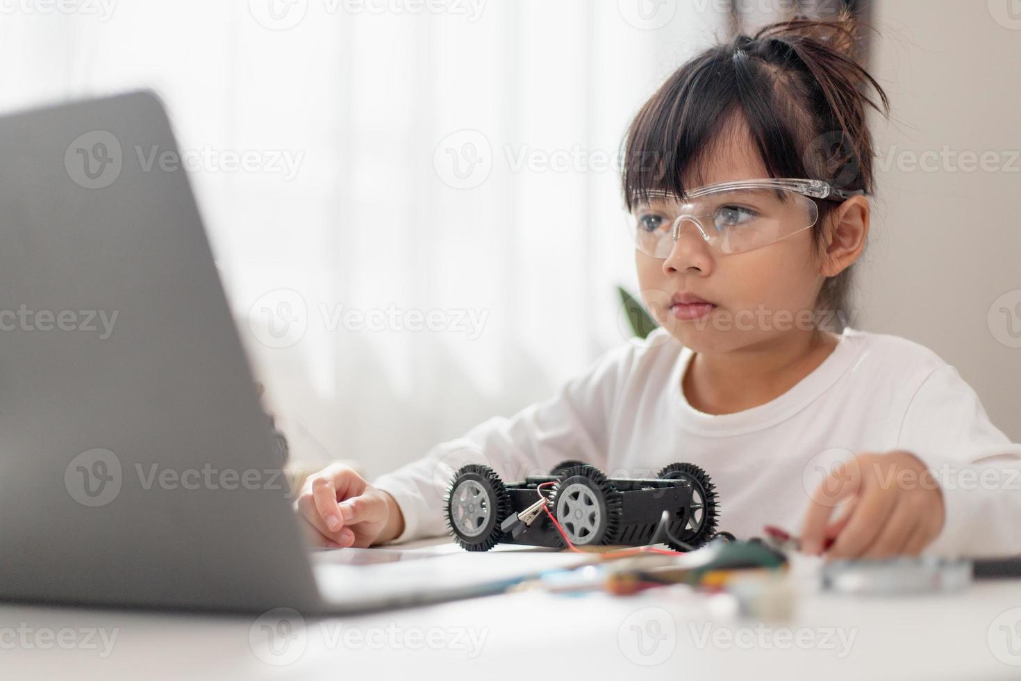 Asia students learn at home in coding robot cars and electronic board cables in STEM, STEAM, mathematics engineering science technology computer code in robotics for kids concept. photo