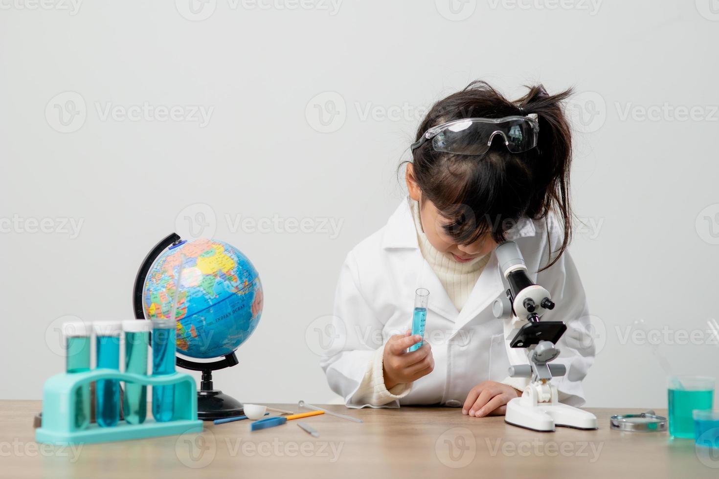 education, science, chemistry and children concept - kids or students with test tube making experiment at school laboratory photo