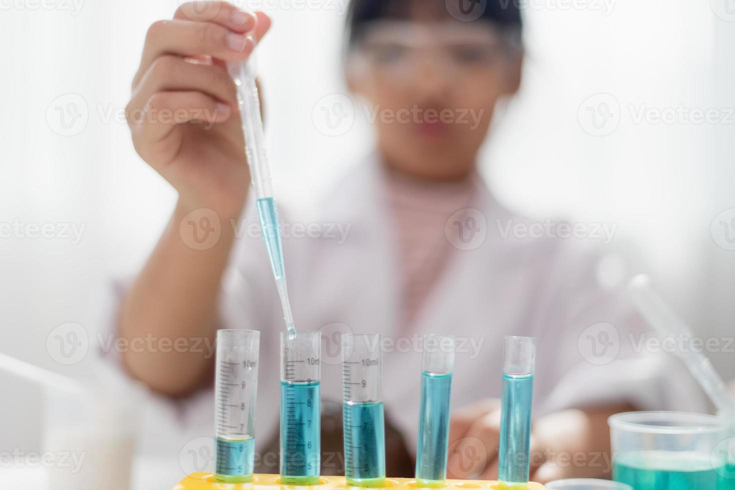 education, science, chemistry and children concept - kids or students with test tube making experiment at school laboratory photo