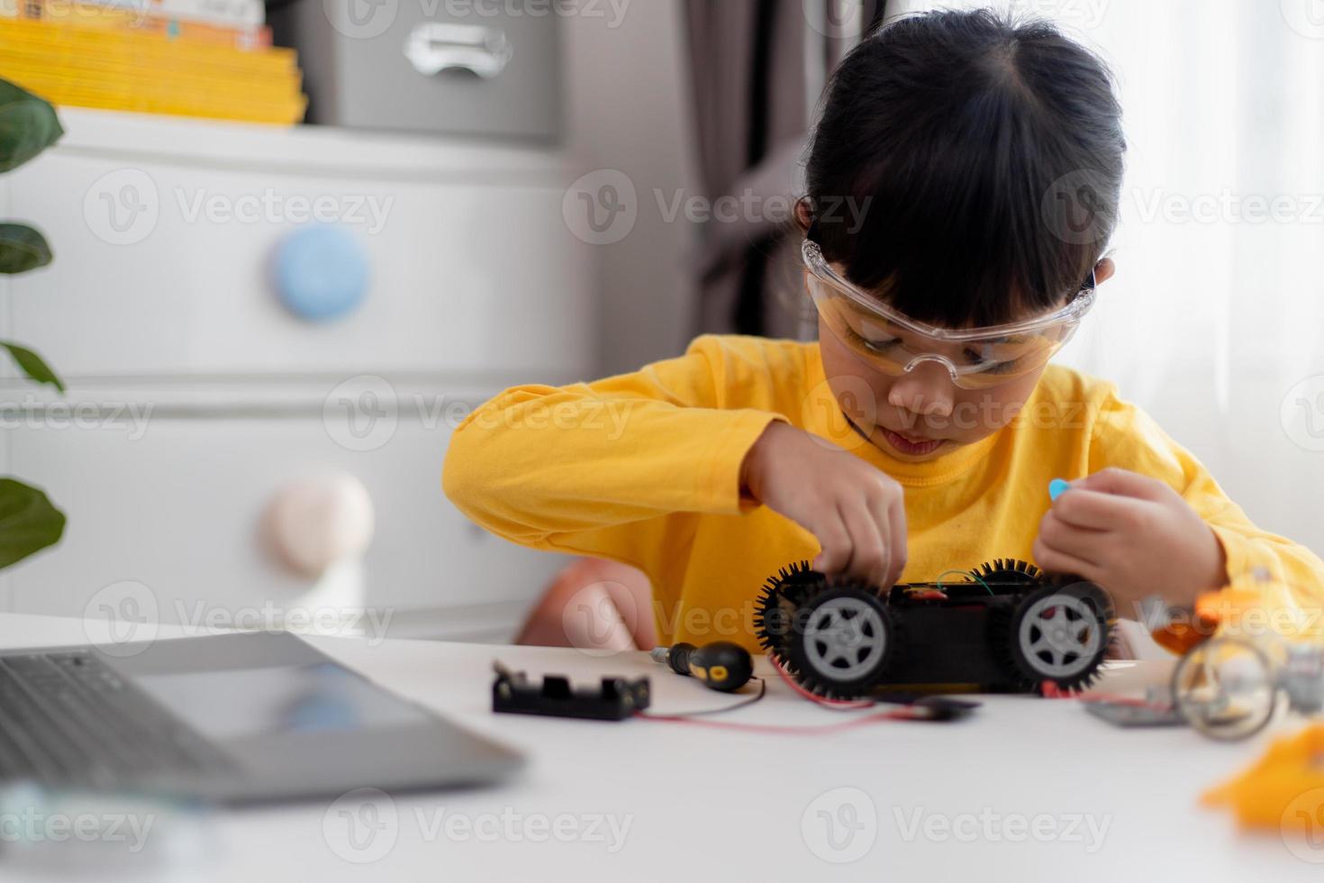 Asia students learn at home in coding robot cars and electronic board cables in STEM, STEAM, mathematics engineering science technology computer code in robotics for kids concept. photo
