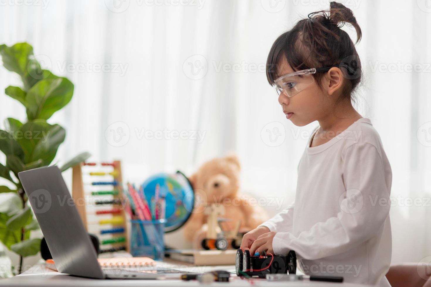 Asia students learn at home in coding robot cars and electronic board cables in STEM, STEAM, mathematics engineering science technology computer code in robotics for kids concept. photo