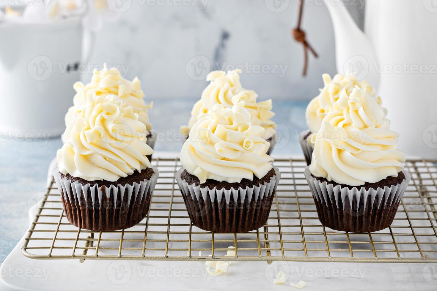 Chocolate cupcakes topped with cream cheese frosting photo