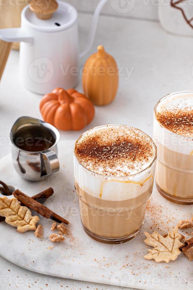 Latte de especias de calabaza cubierto con espuma de leche y espolvoreado con canela foto