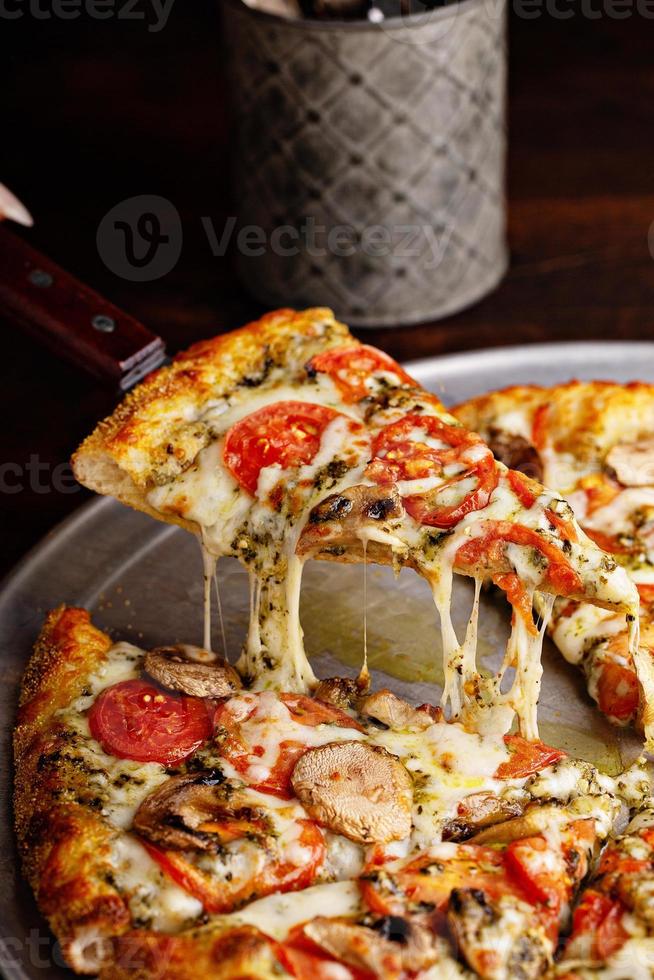 Vegetarian pizza with mushrooms and pesto sauce photo