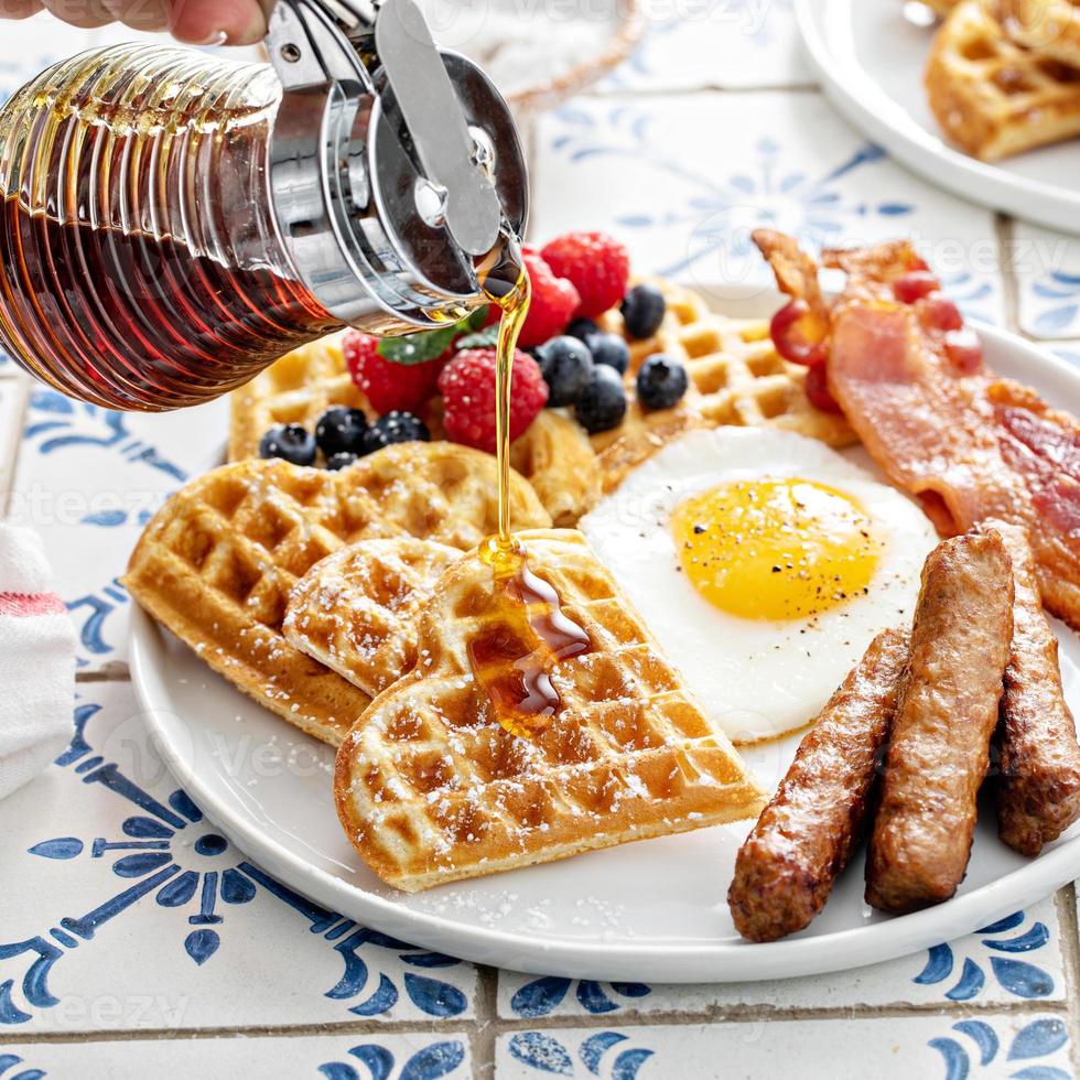 Breakfast table with waffles. fried egg, bacon and sausage photo