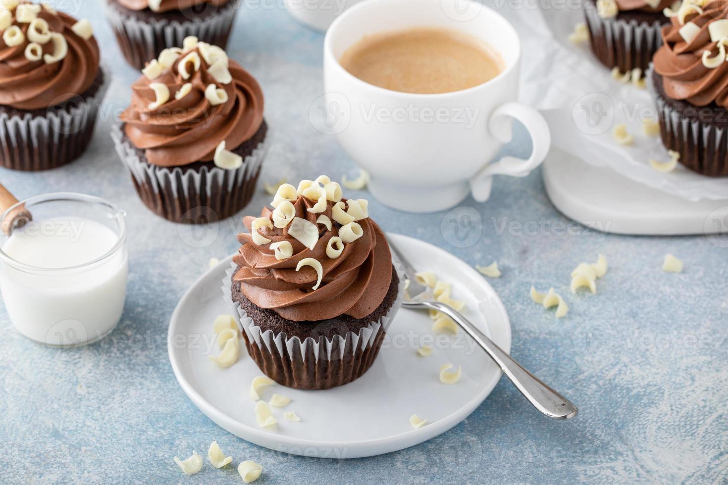 Dark chocolate cupcakes with whipped ganache frosting and white chocolate curls photo