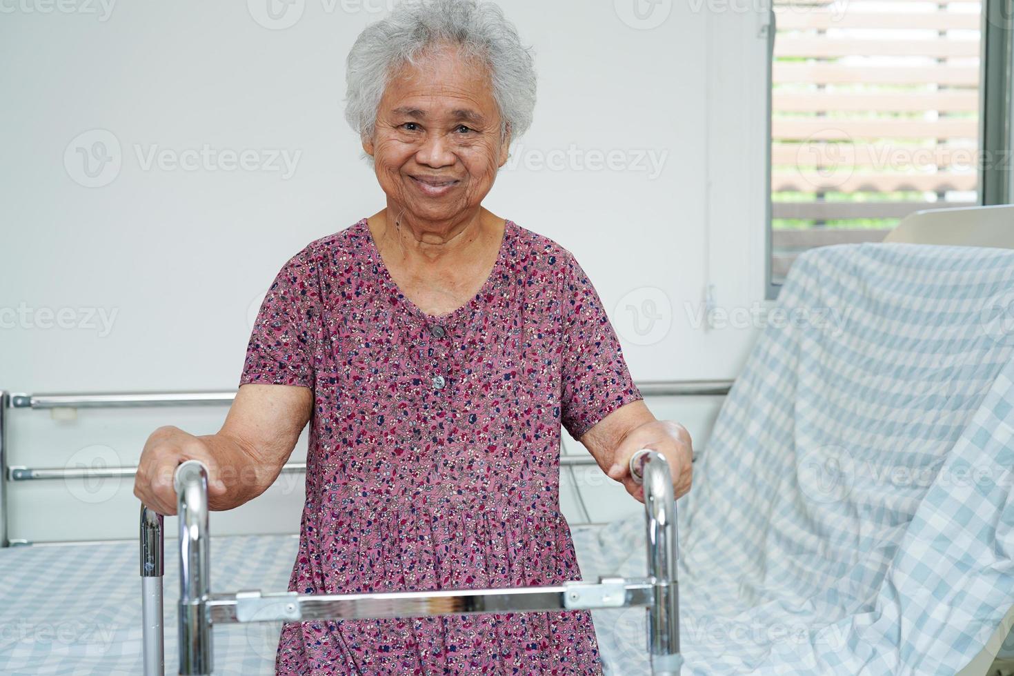 anciana asiática discapacitada paciente camina con andador en el hospital de enfermería, concepto médico. foto