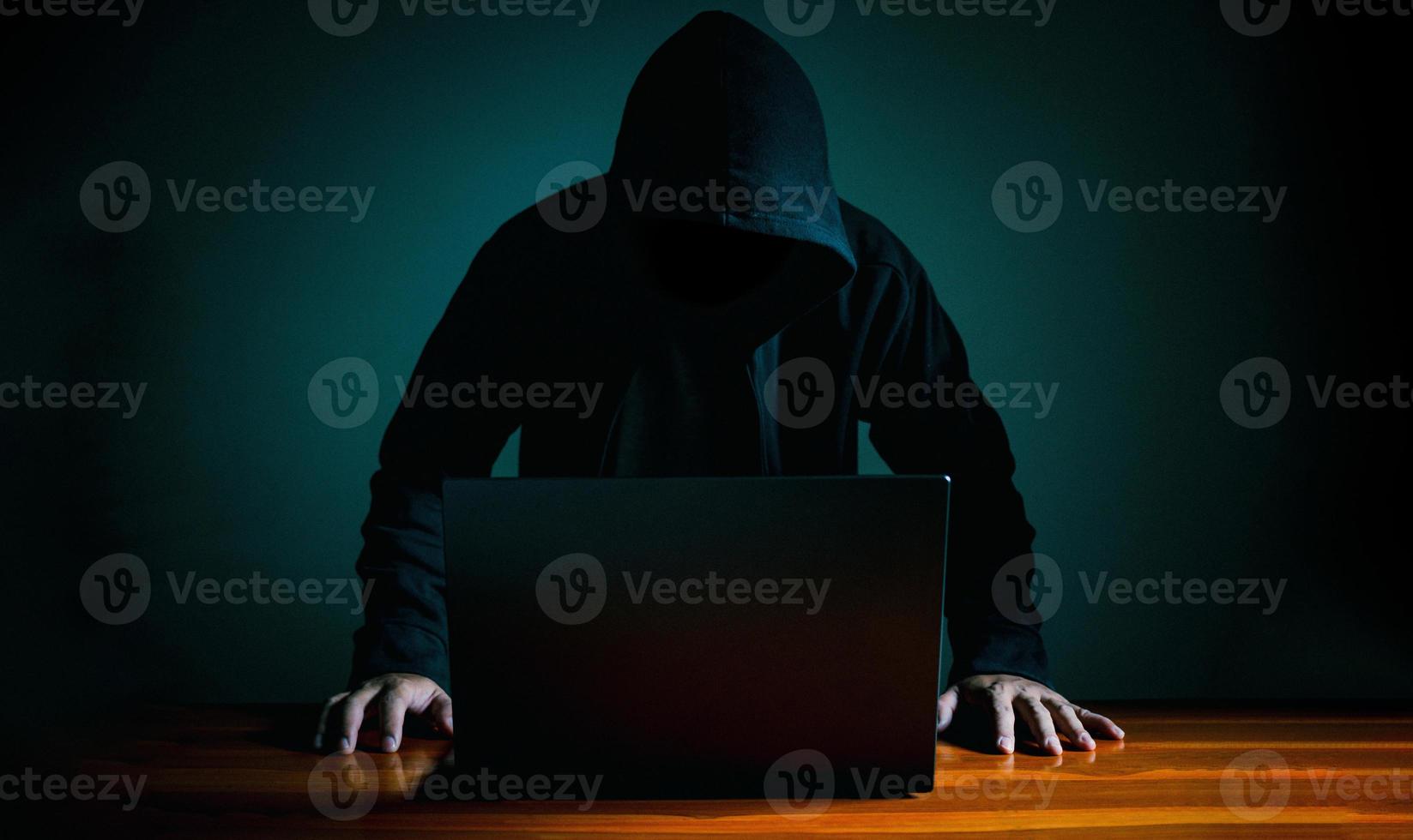 Hackers work on laptops in the dark. The concept of information security in the Internet network and information espionage. photo