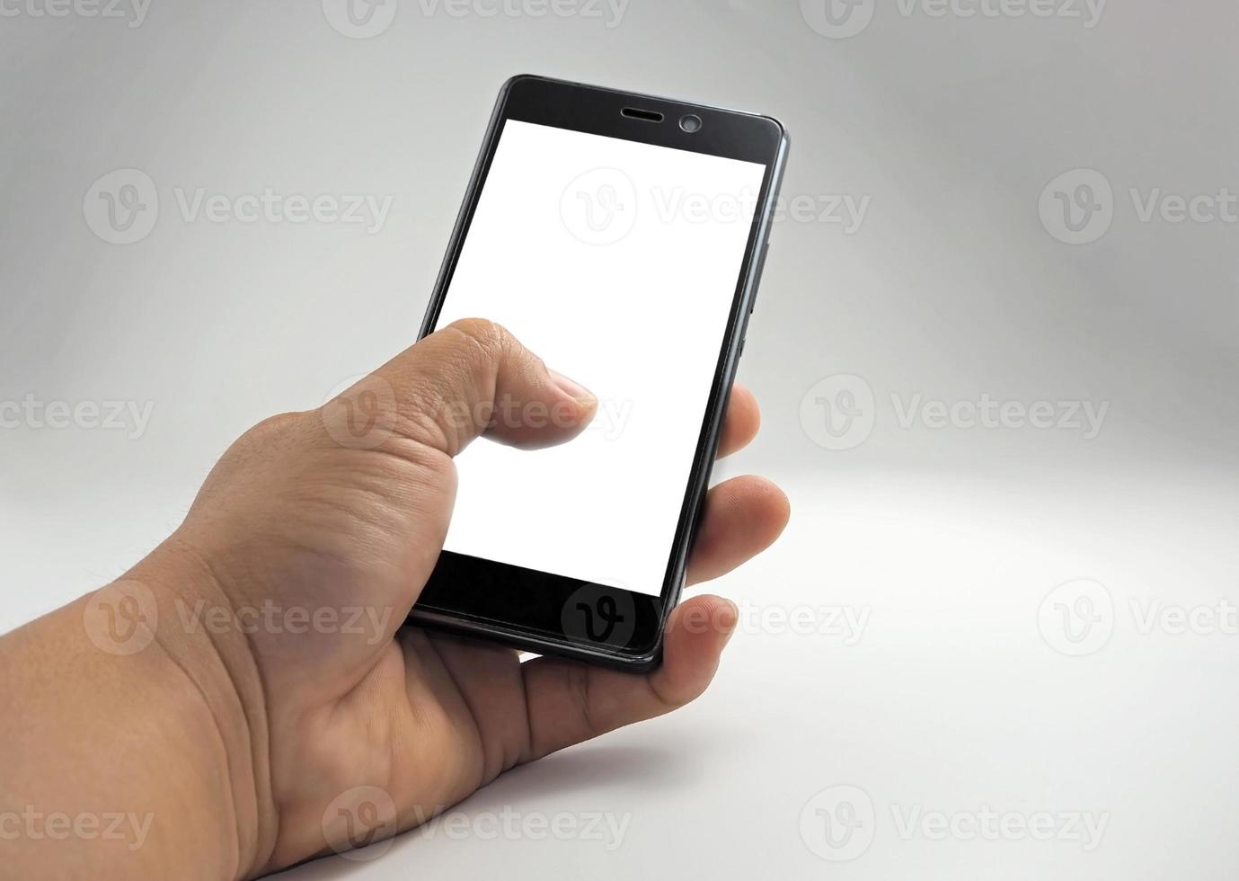 Human hand holding blank screen smart phone isolated on white background. photo