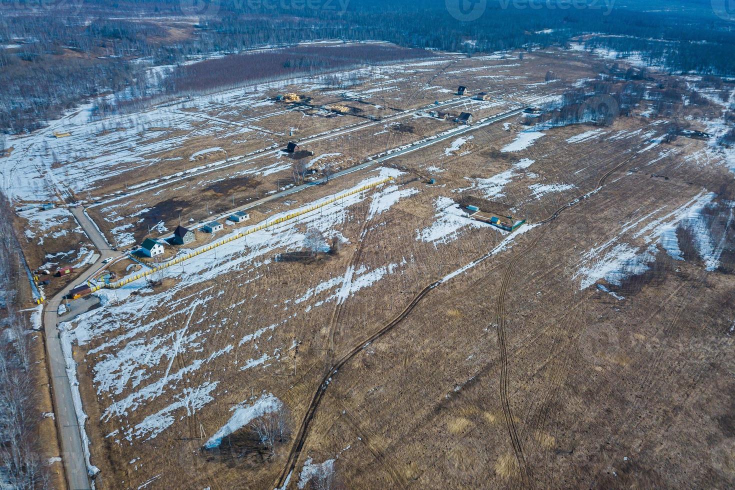 Aerial drone top view photo of track road in the industrial area with construction sites in the springtime with unmelted ice