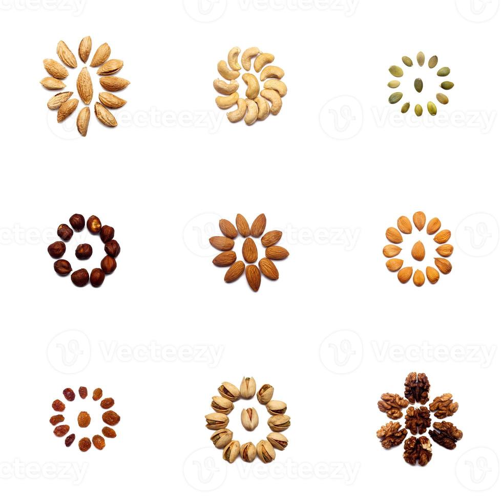 una colección de nueces hechas de almendras, nueces, avellanas, pistachos, anacardos se encuentran en forma de círculo o el sol sobre un fondo blanco aislado con un sendero recortado. varios patrones de nueces foto