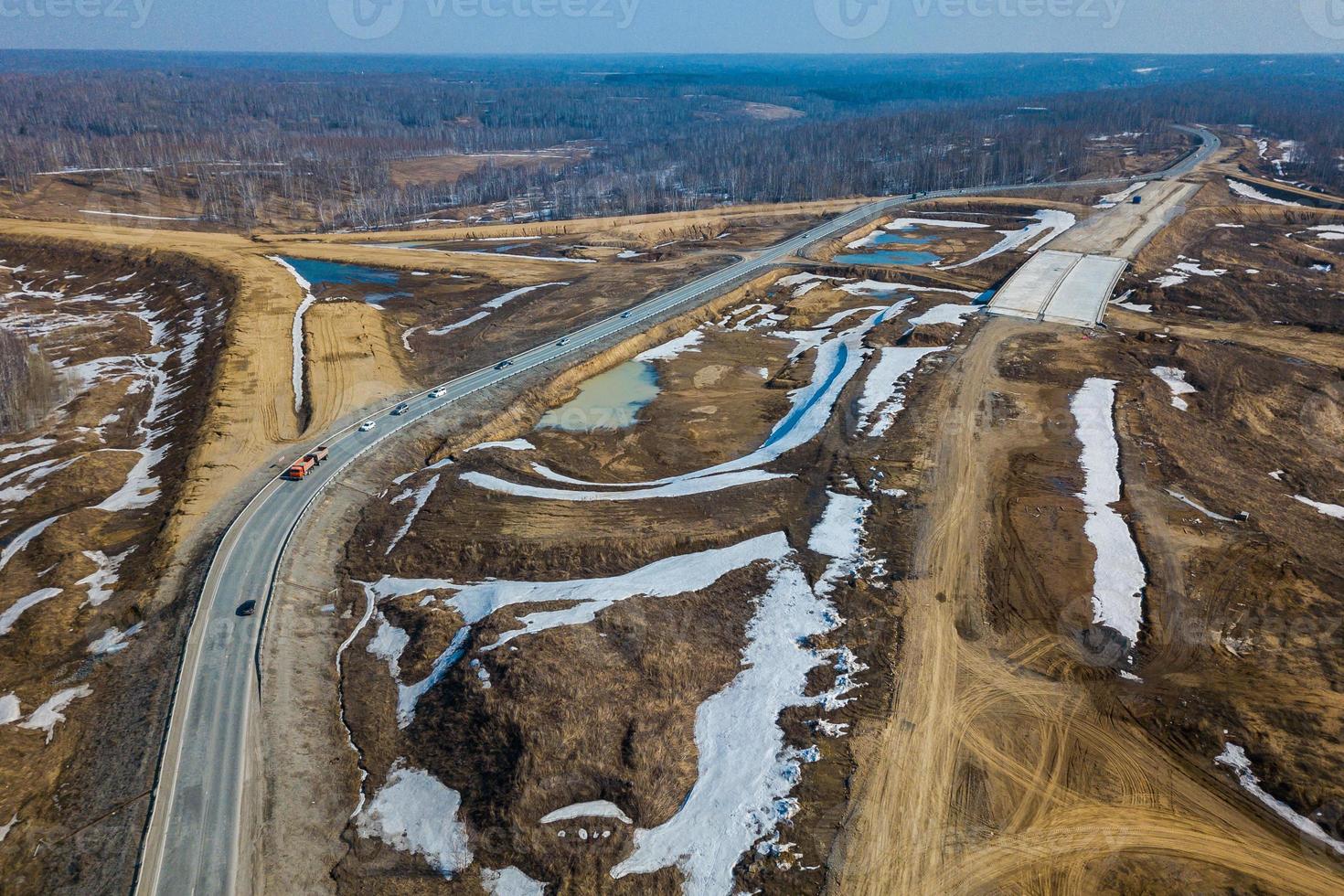 Vertical aerial wide angle drone view of road with car, on background forest, construction site. photo