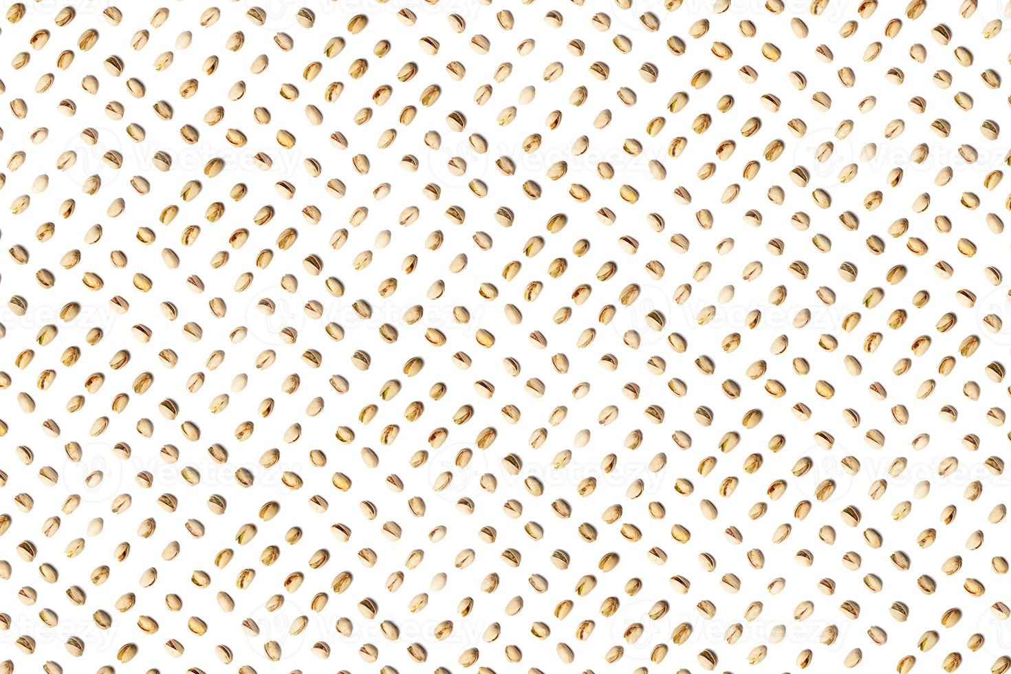 A collection of pistachio nuts lie in horizontal rows on an isolated white background. with clipping path. Pistachio pattern photo
