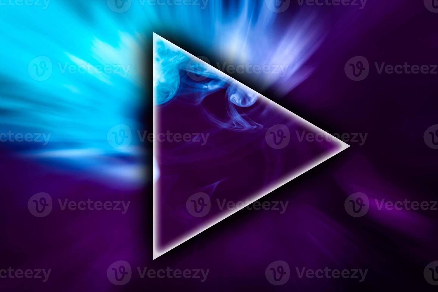 Fog colored with bright pink and blue gel in the shape of a triangle on dark background photo