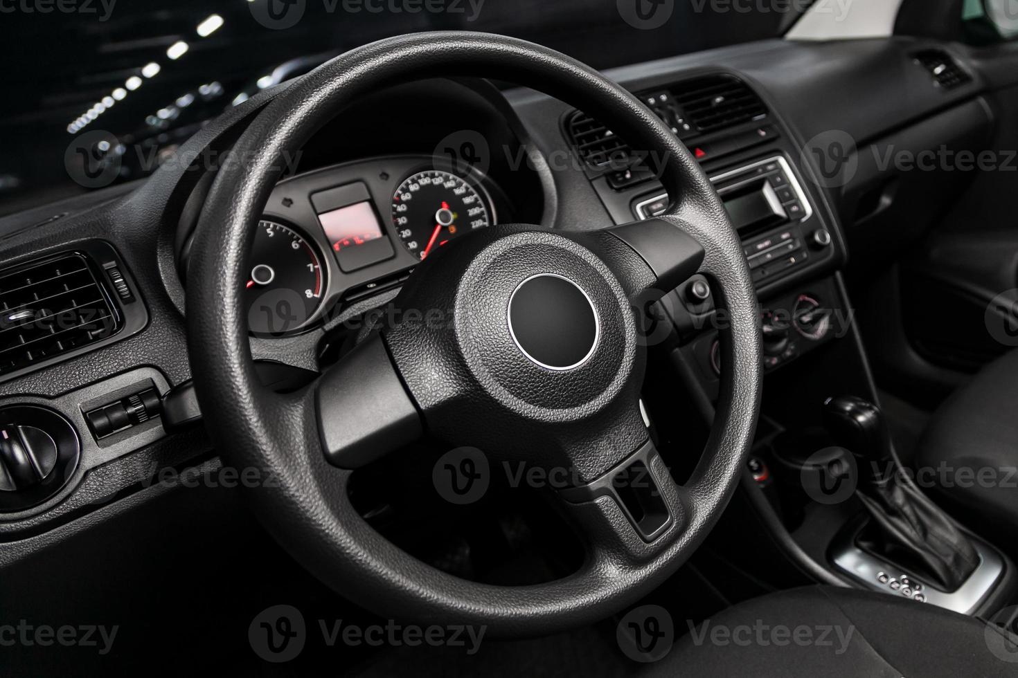 dashboard, speedometer, tachometer and steering wheel with wooden inserts with phone setting and volume buttons. Luxurious car interior details photo