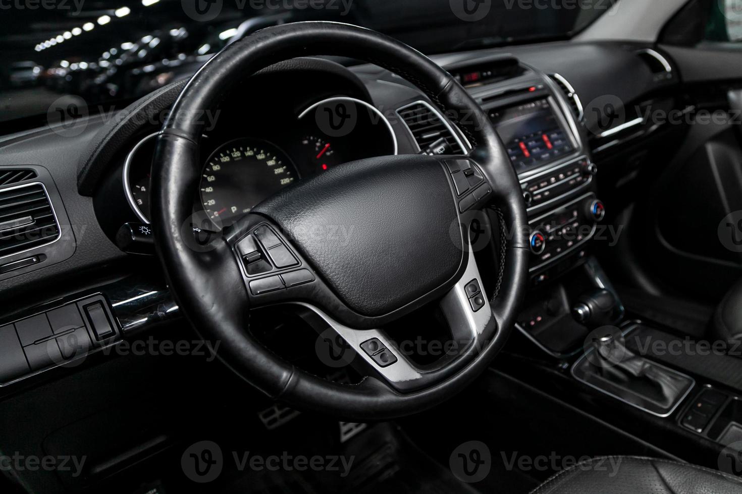 dashboard, speedometer, tachometer and steering wheel with wooden inserts with phone setting and volume buttons. Luxurious car interior details photo