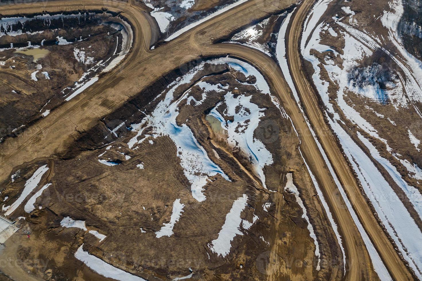 Vertical aerial wide angle drone view of road with car, on background forest, construction site. photo