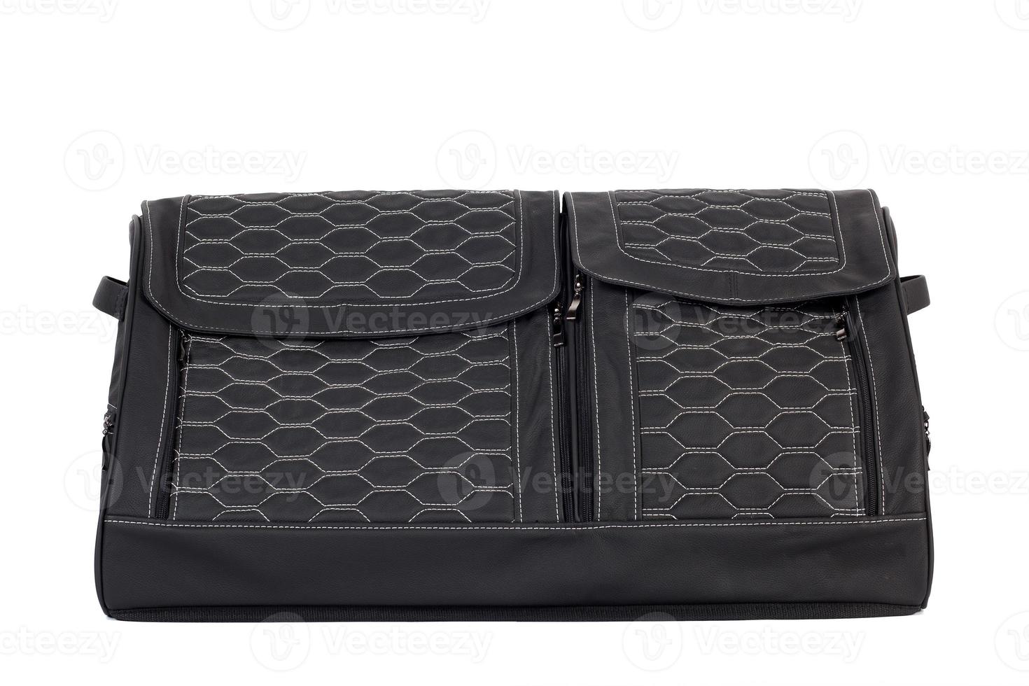 bolsa de cuero negro para guardar cosas y viajar en el maletero de un coche sobre un fondo blanco aislado. equipaje, maleta hecha a mano foto