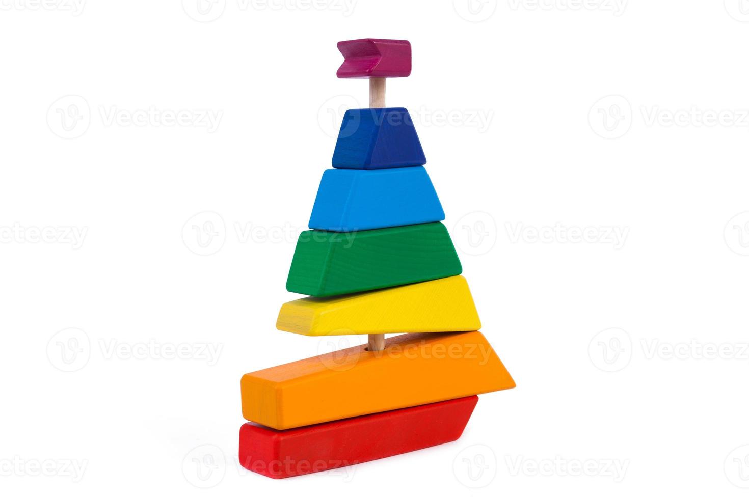 Photo colorful wooden constructor of small arcs, triangles and other forms  in the shape of a ship of beech on a white isolated background