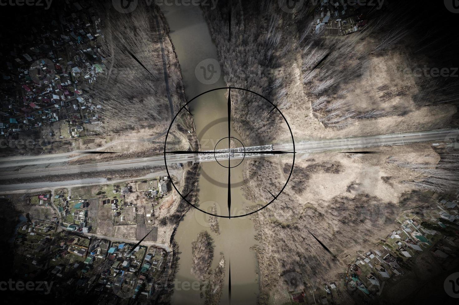 Close up, a small town, a village with small houses, a river, a bridge, roads and other strategically important objects to be under the gun and shadowed. Concept of computer game and spying on people photo