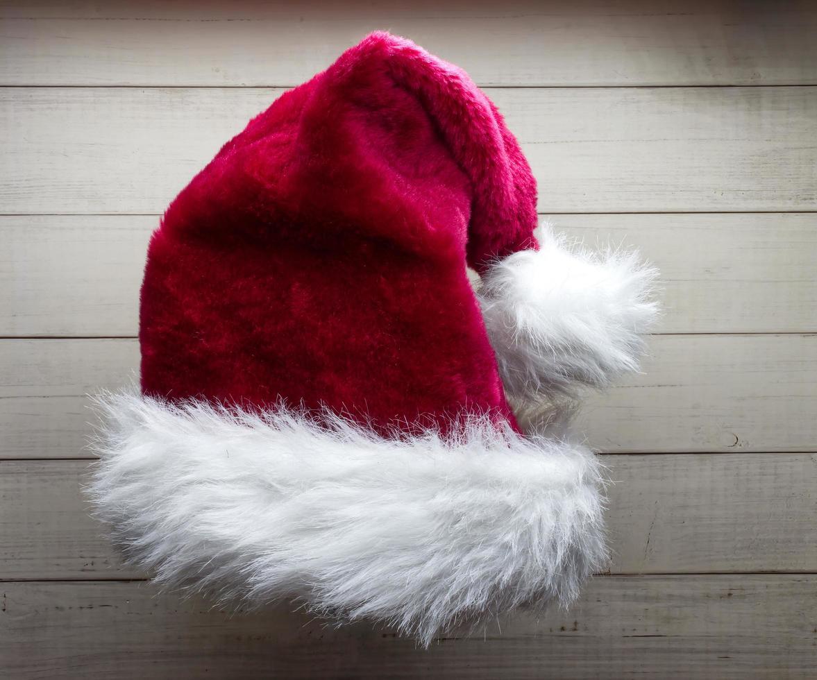 Red Santa Claus hat isolated on wooden background. photo