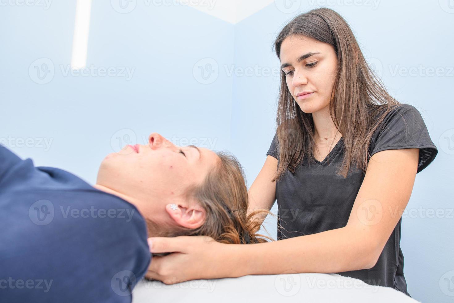 un fisioterapeuta durante un tratamiento cervical foto