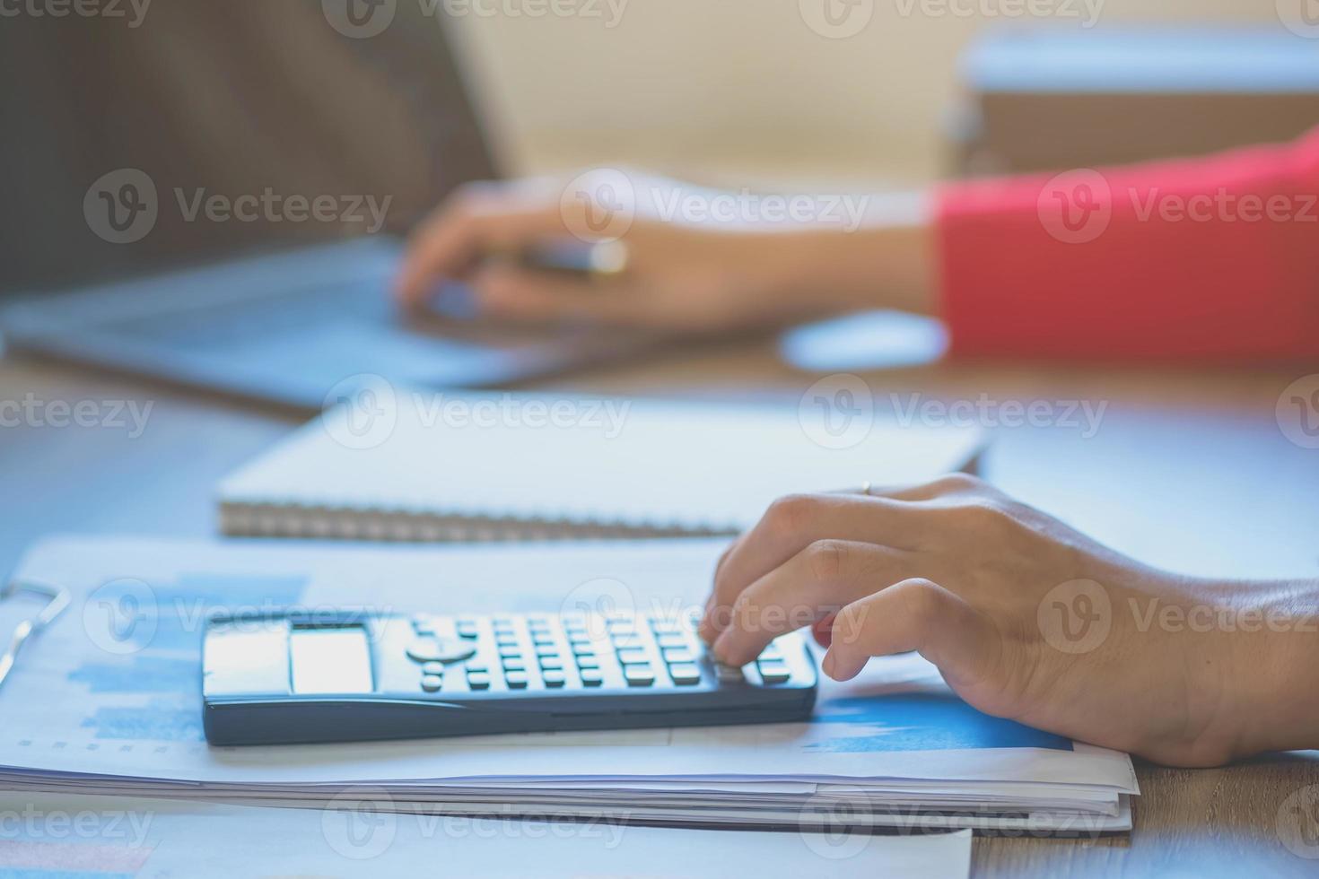 marketing, finanzas, contabilidad, planificación, retrato de una contadora que usa una calculadora y una computadora portátil para calcular el saldo usando gráficos para los clientes. foto