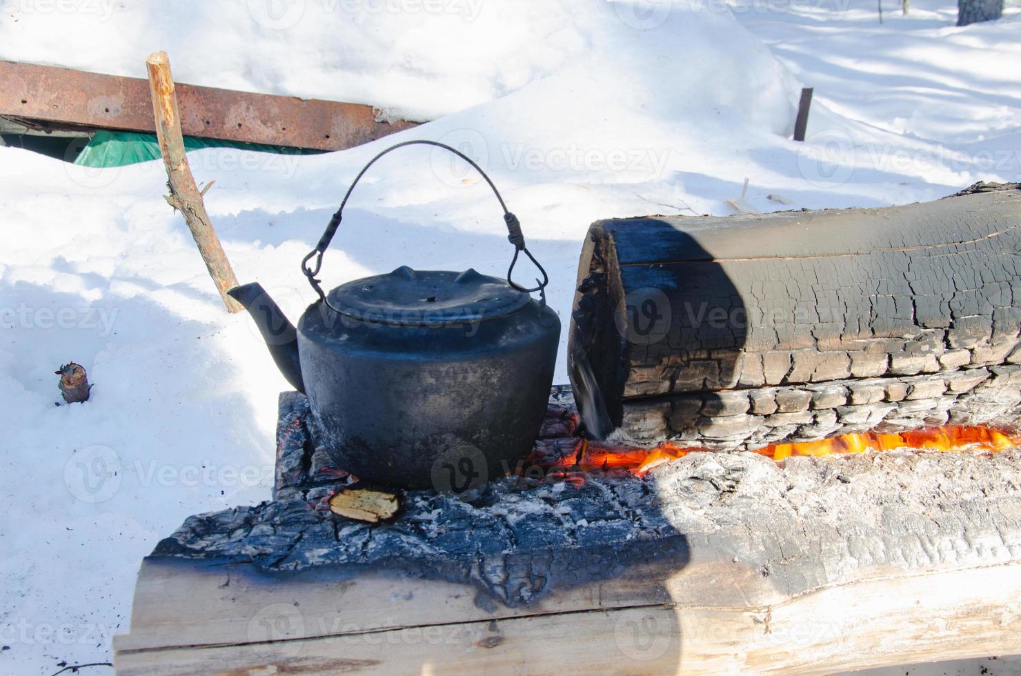 heat a kettle on logs in the forest. campfire nodya. photo