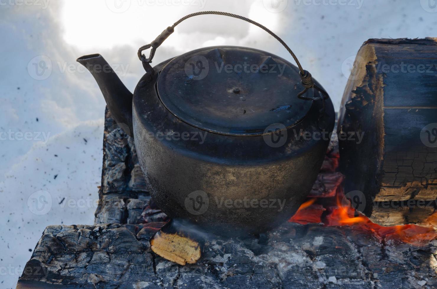 heat a kettle on logs in the forest. campfire nodya. photo