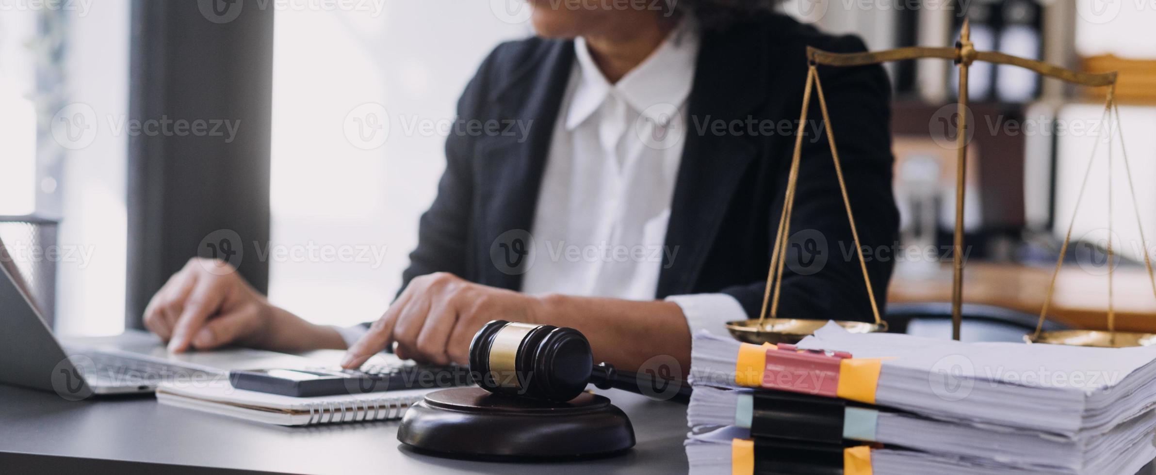 law books and scales of justice on desk in library of law firm. jurisprudence legal education concept. photo