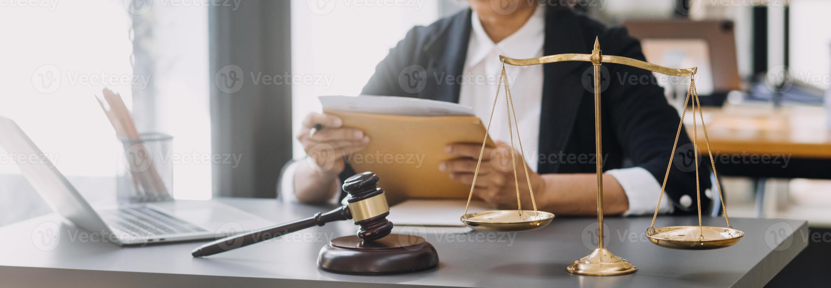 law books and scales of justice on desk in library of law firm. jurisprudence legal education concept. photo