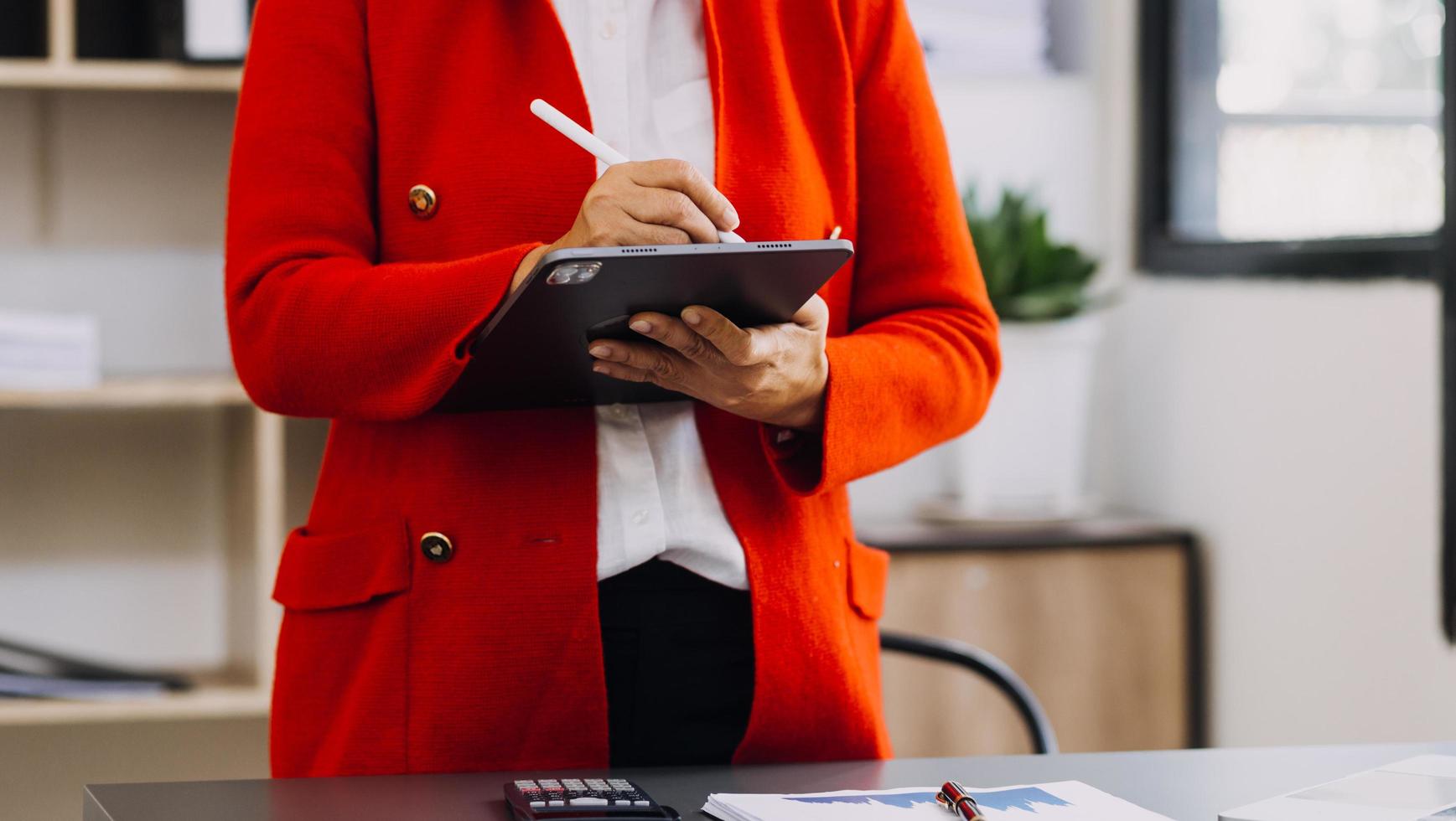 mano de mujer de negocios trabajando con computadora portátil, tableta y teléfono inteligente en la oficina moderna con diagrama de icono virtual en la oficina moderna a la luz de la mañana foto