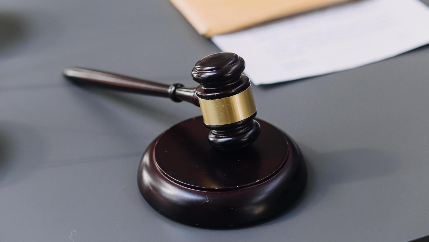 Business and lawyers discussing contract papers with brass scale on desk in office. Law, legal services, advice, justice and law concept picture with film grain effect photo