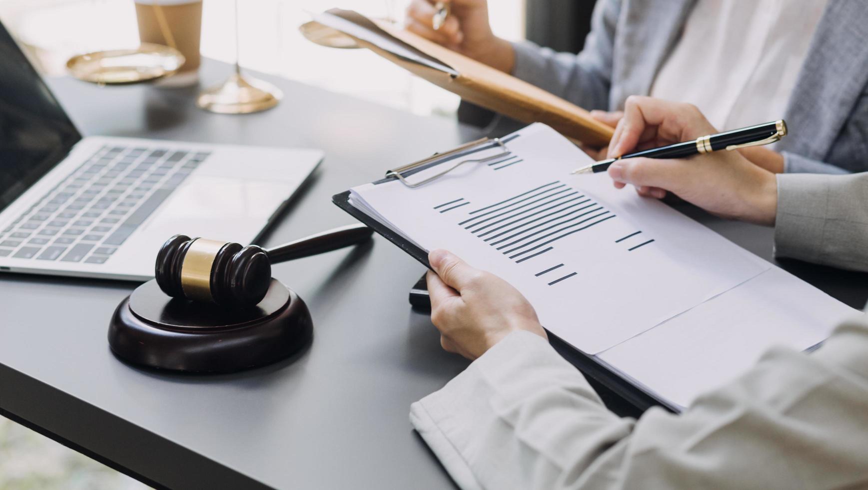 Business and lawyers discussing contract papers with brass scale on desk in office. Law, legal services, advice, justice and law concept picture with film grain effect photo