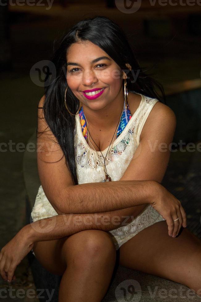 encantadora joven brasileña con una hermosa sonrisa en el parque por la noche foto