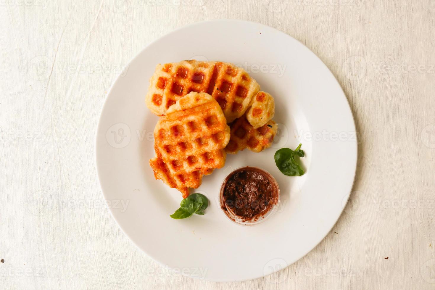 gofre croissant o croffle con salsa de chocolate servido en caja y fondo blanco foto