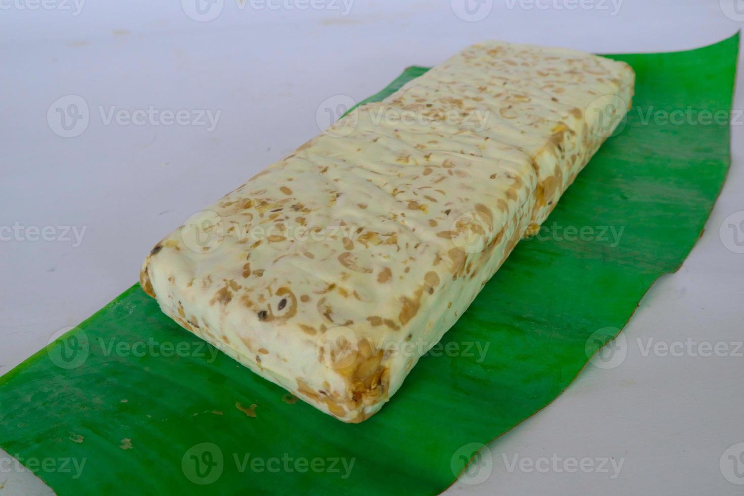 Raw tempeh or tempe. tempeh slices in white background. raw soybean seeds. Tempe is a traditional Indonesian food made from fermented soybeans. photo