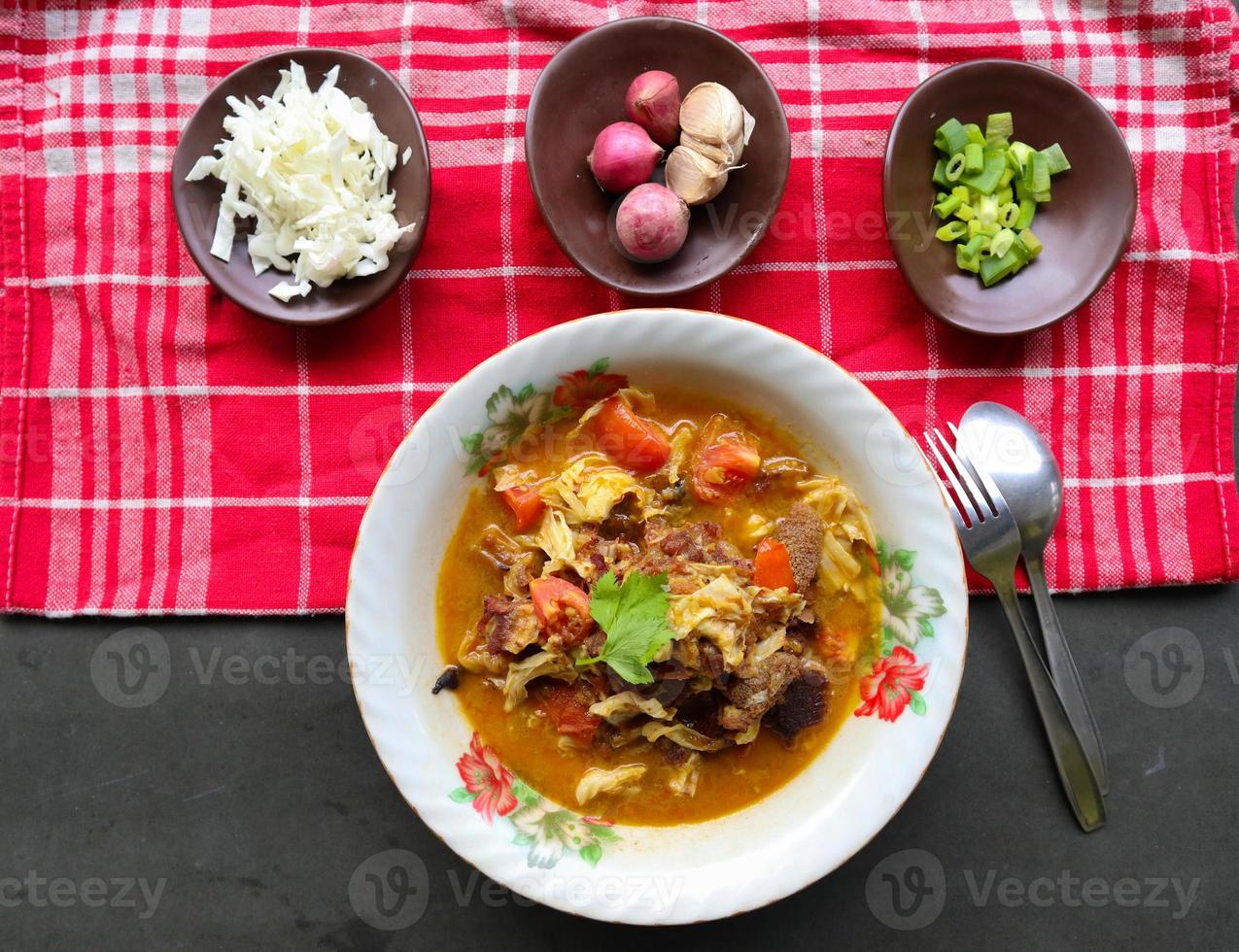 Goat Curry or gulai kambing, food from asia. Delicious goat meat curry served in a bowl.served with tomato, seasoning, celery and cabbage photo