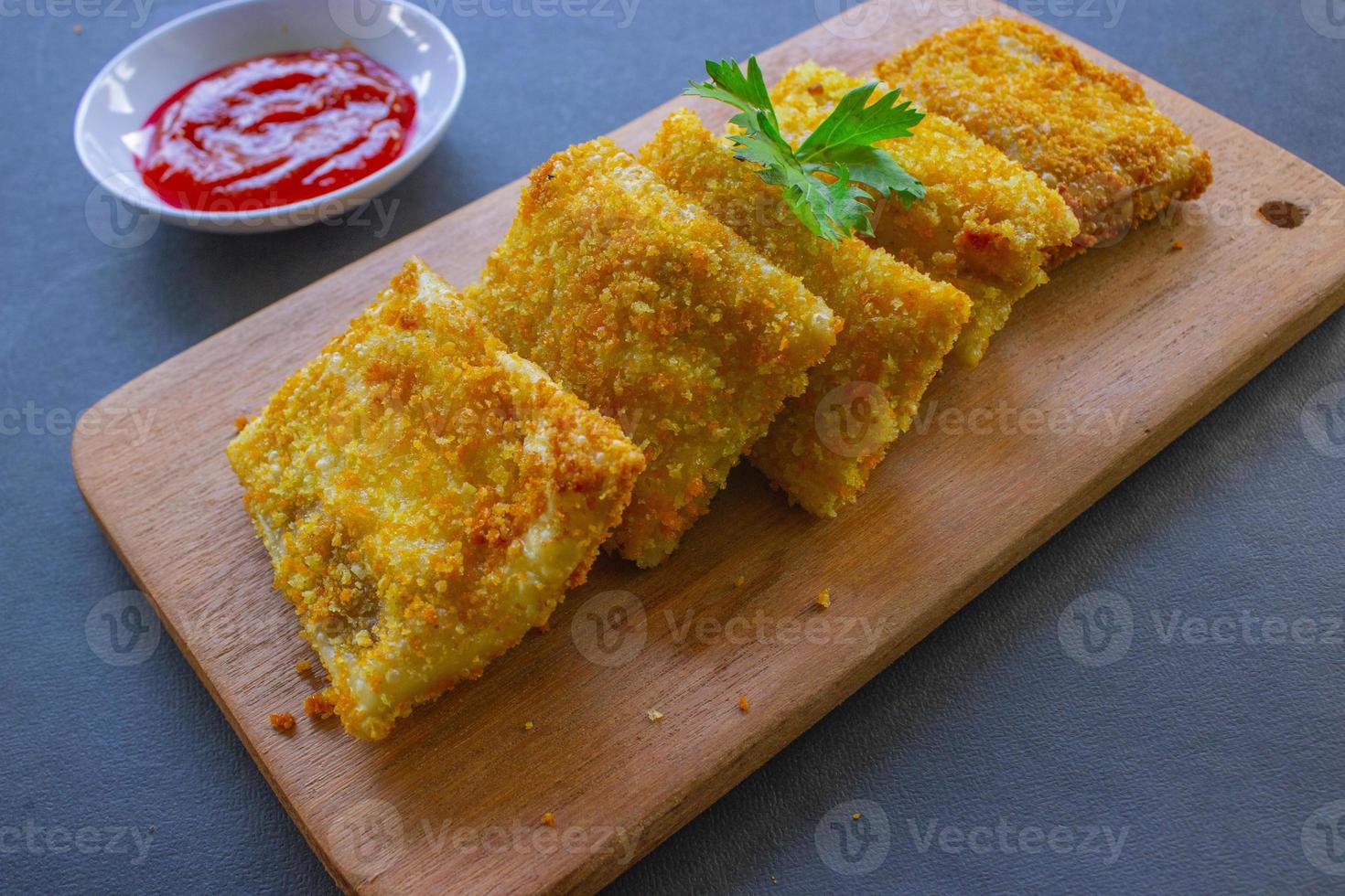 Fried Risoles or Risol Mayo are Indonesian snacks. Like Coxinha de Galinha. served with chili sauce, celery on wood board photo