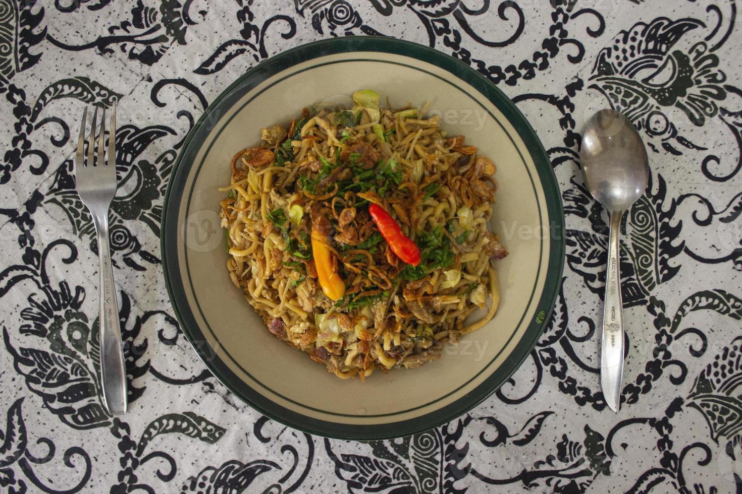 Mie Goreng Jawa or bakmi jawa or java noodle with spoon and fork. Indonesian traditional street food noodles from central java or Yogyakarta, indonesia on white background photo