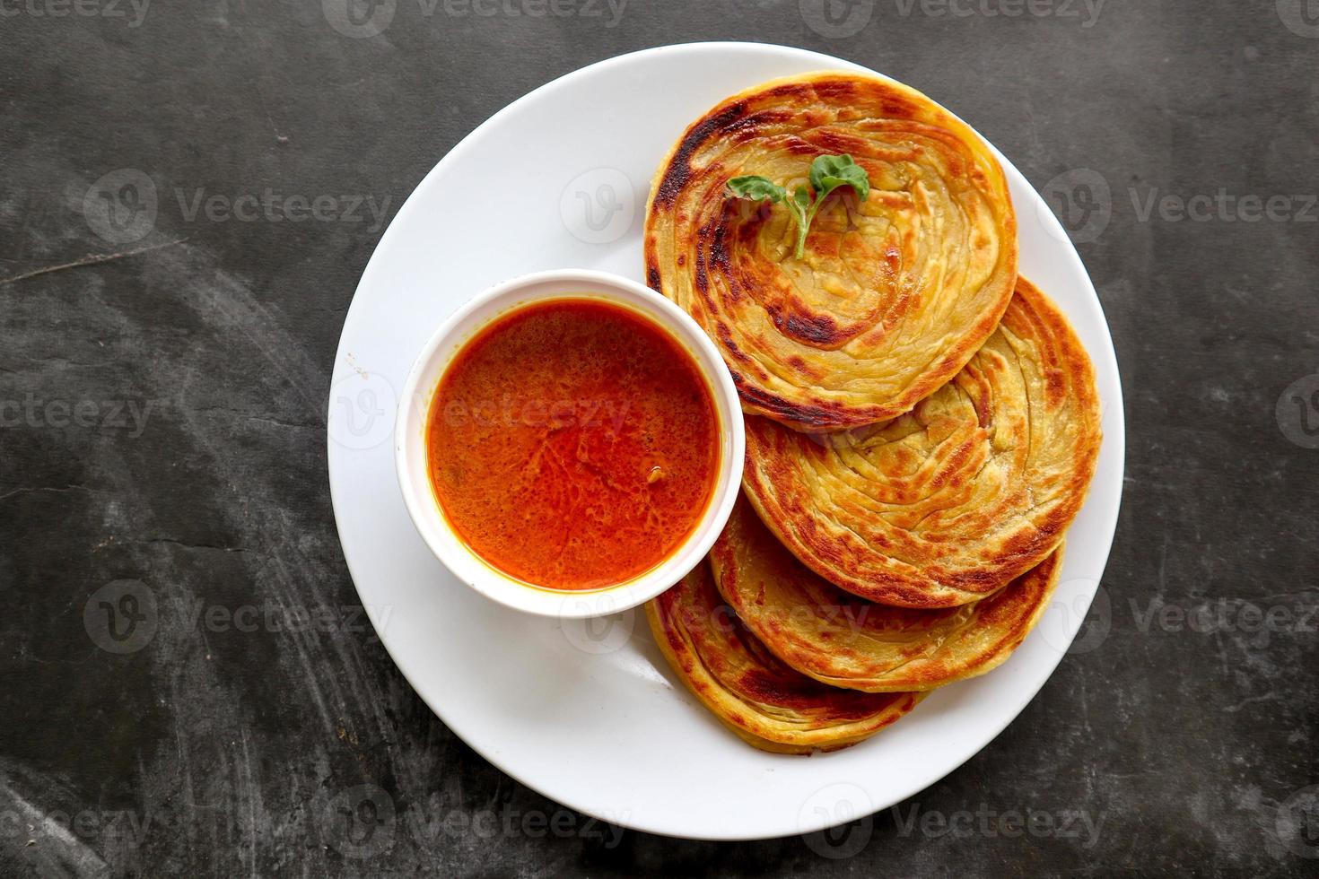 paratha bread or canai bread or roti maryam, favorite breakfast dish. served on plate photo